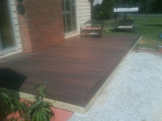 Freshly stained wood deck built against a brick home in Harvey